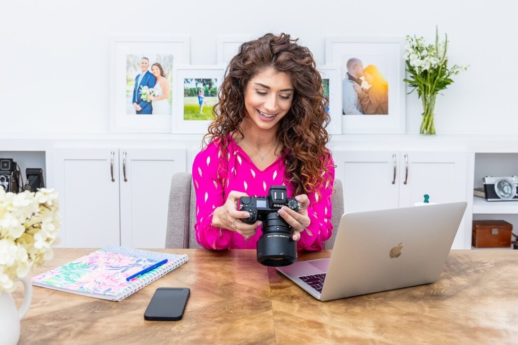 Photographer reviewing images with camera and laptop during Black Friday sale season