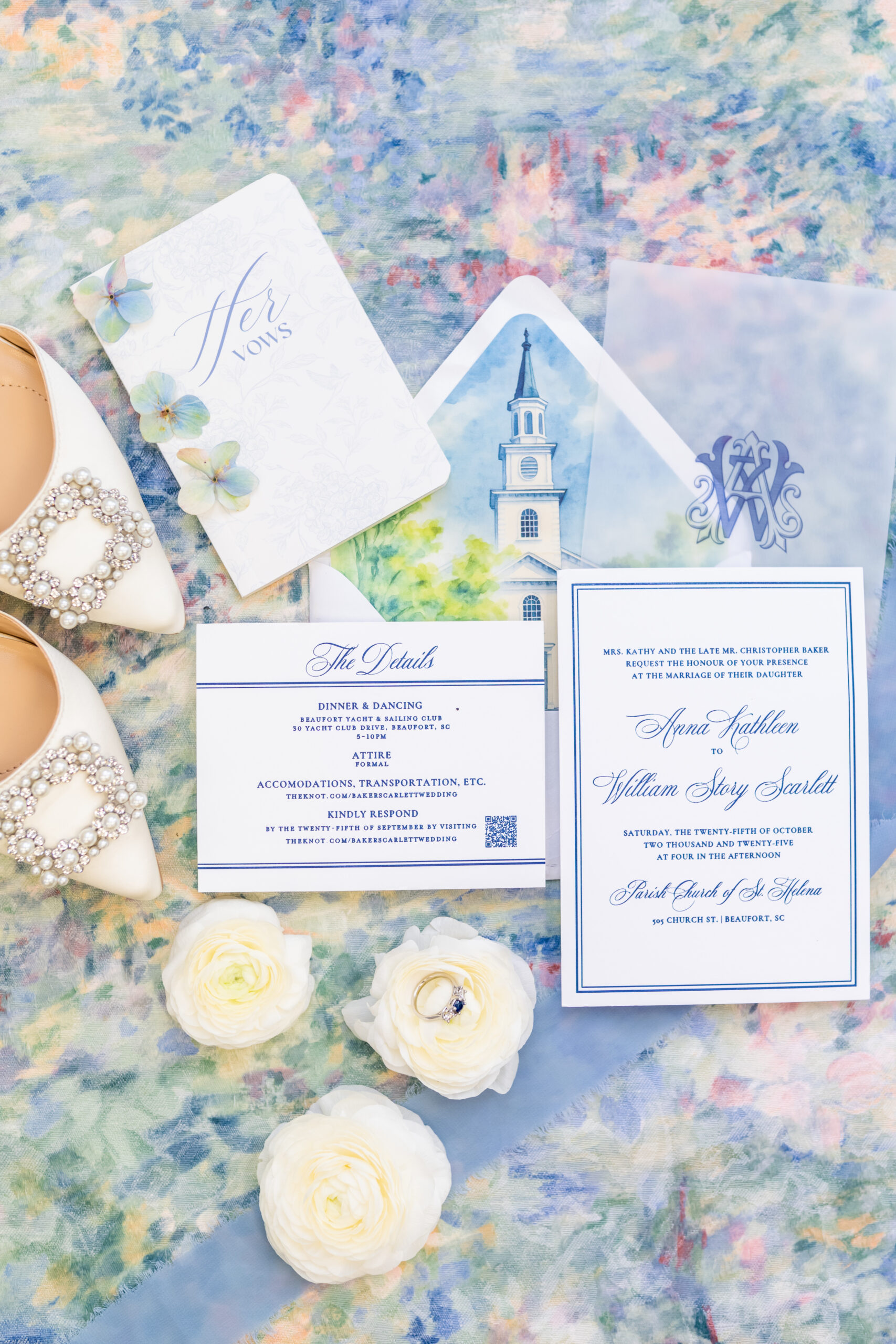 Classic navy calligraphy wedding invitation suite flat lay with a watercolor church envelope liner, vow booklet, pearl bridal shoes, and engagement ring styled with white roses, photographed by Maryland wedding photographer Jennifer Mary Collective