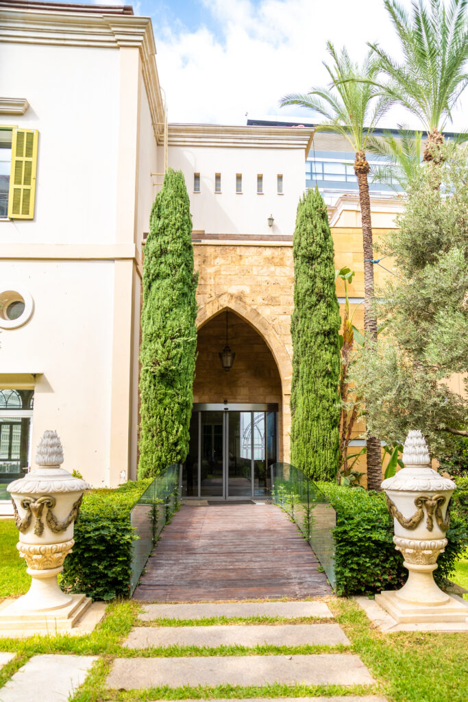 Grand arched entrance with tall cypress trees and gardens in Beirut Lebanon