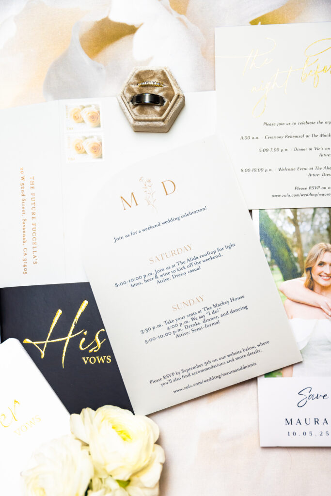 Modern minimal wedding invitation suite flat lay with a gold monogram, his and her vow booklets, a hexagonal ring box, and a save the date card, photographed by Maryland wedding photographer Jennifer Mary Collective